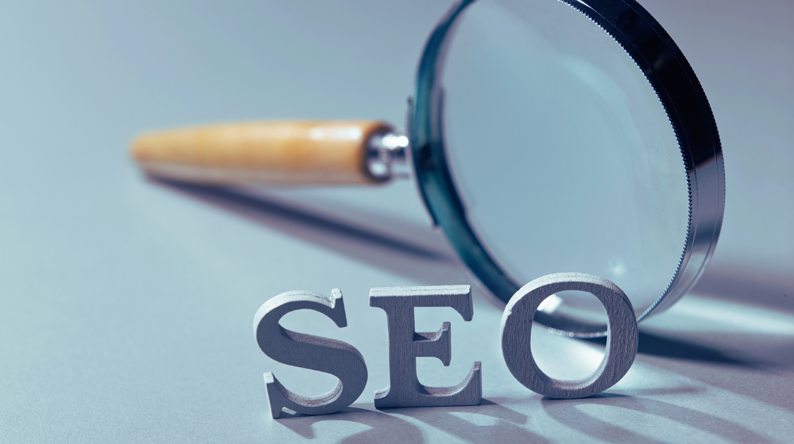 The word 'SEO' with a magnifying glass, representing search engine optimization and digital marketing strategies
