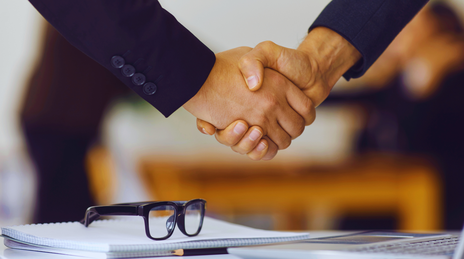Close-up of business partners shaking hands making deal and confirming collaboration